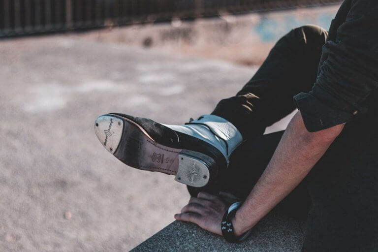 Tap shoes - a man on sitting down, so you can see the sole of his tap shoes
